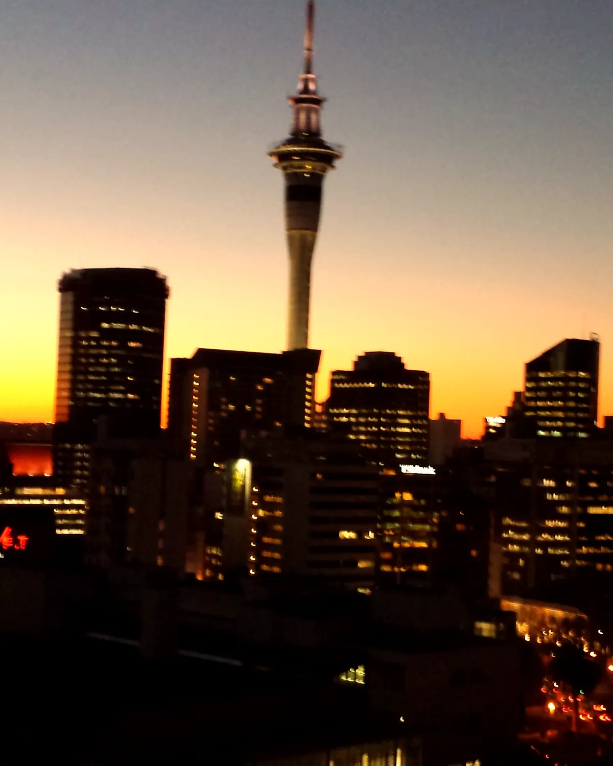 Auckland skyline at dusk, the Sky Tower above the harbour