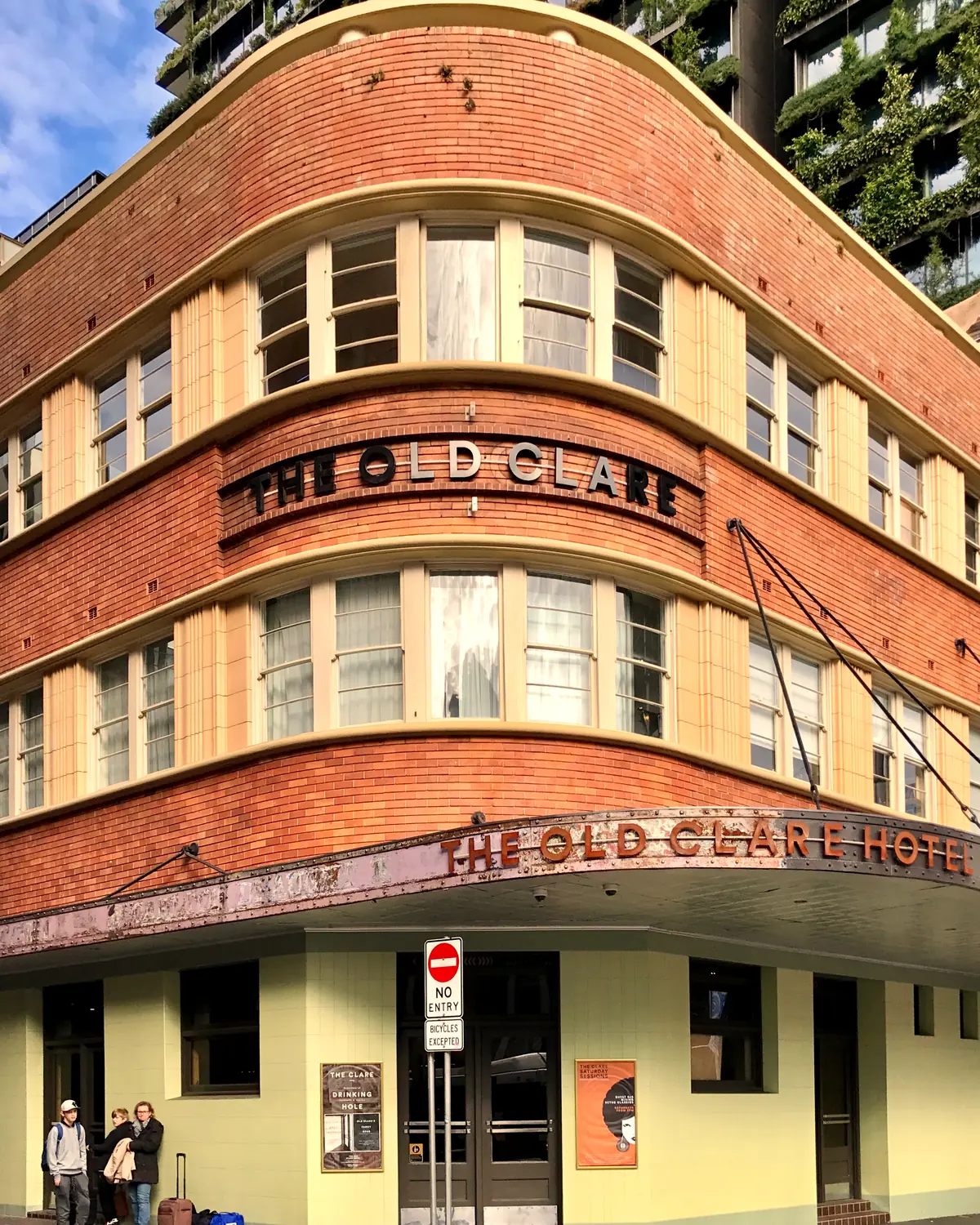 Curved Art Deco brick corner of the hotel with "The Old Clare" and "The Old Clare Hotel" lettering on the facade and awning; taken June 2017